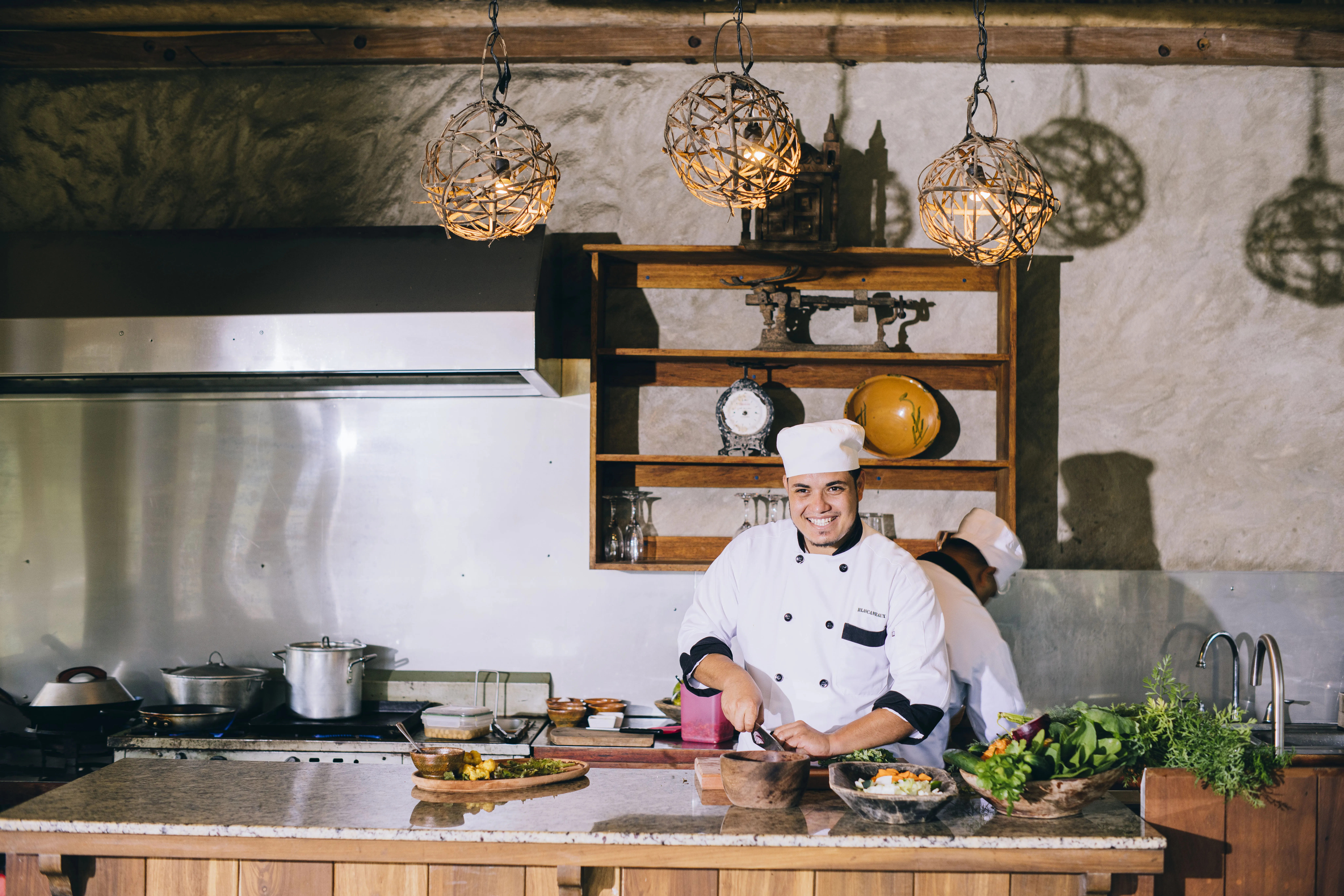 A smiling chef chopping vegetables
