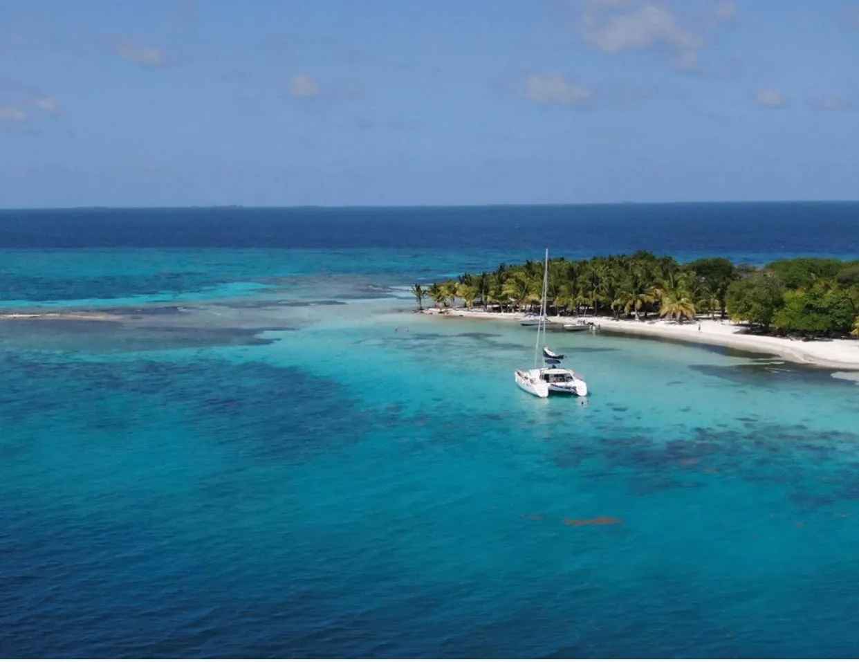 A white boat in blue water just offshore