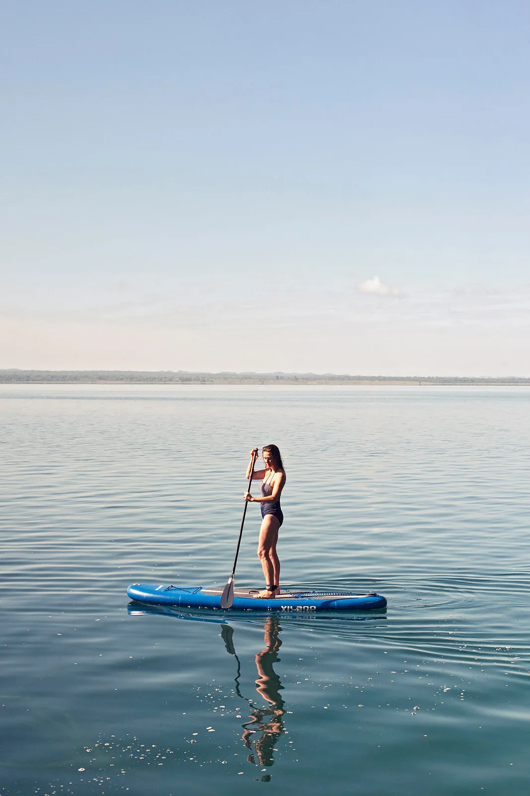 A patron of La Lancha paddle-boarding on the lake.