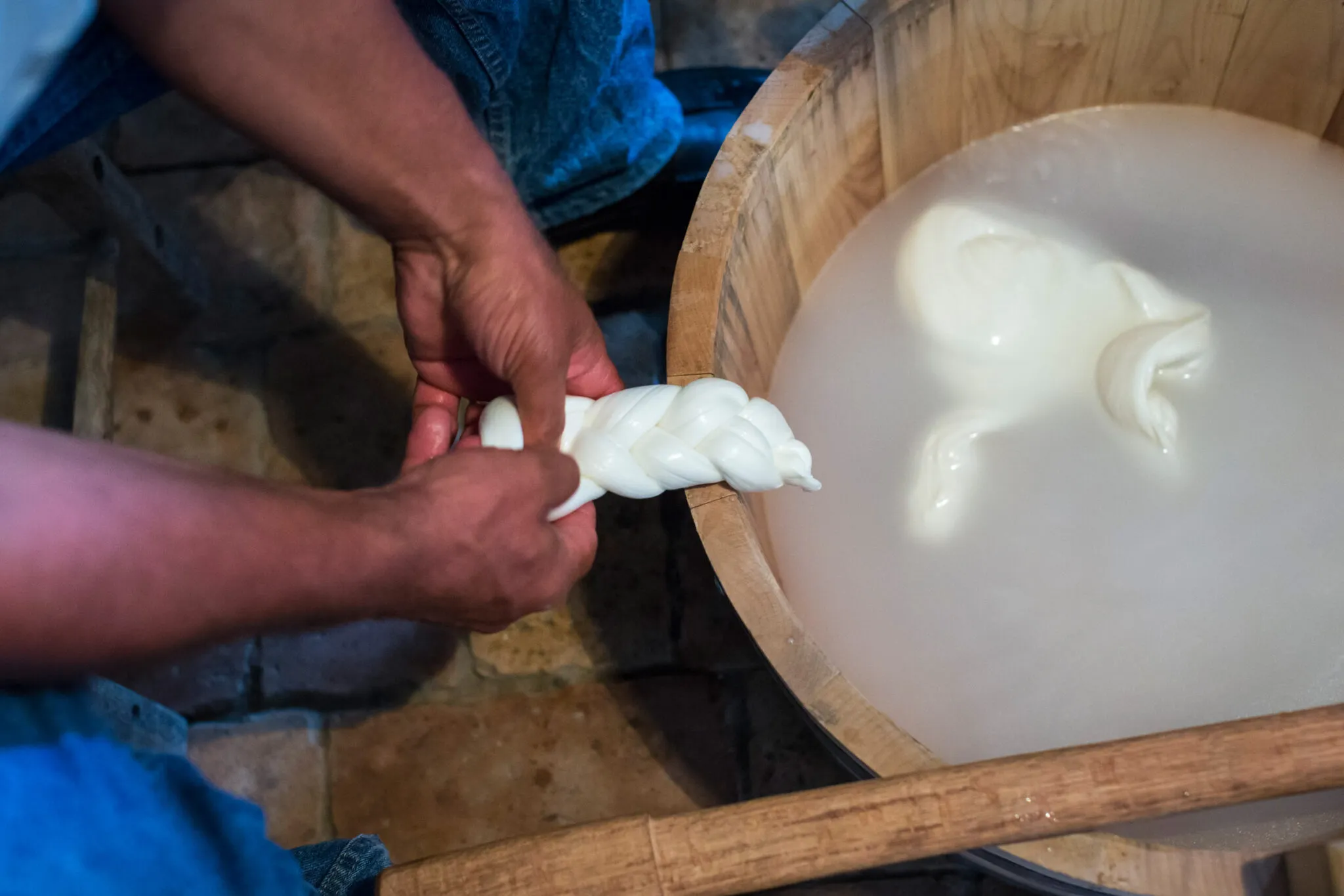A person braids strands of fresh mozzarella