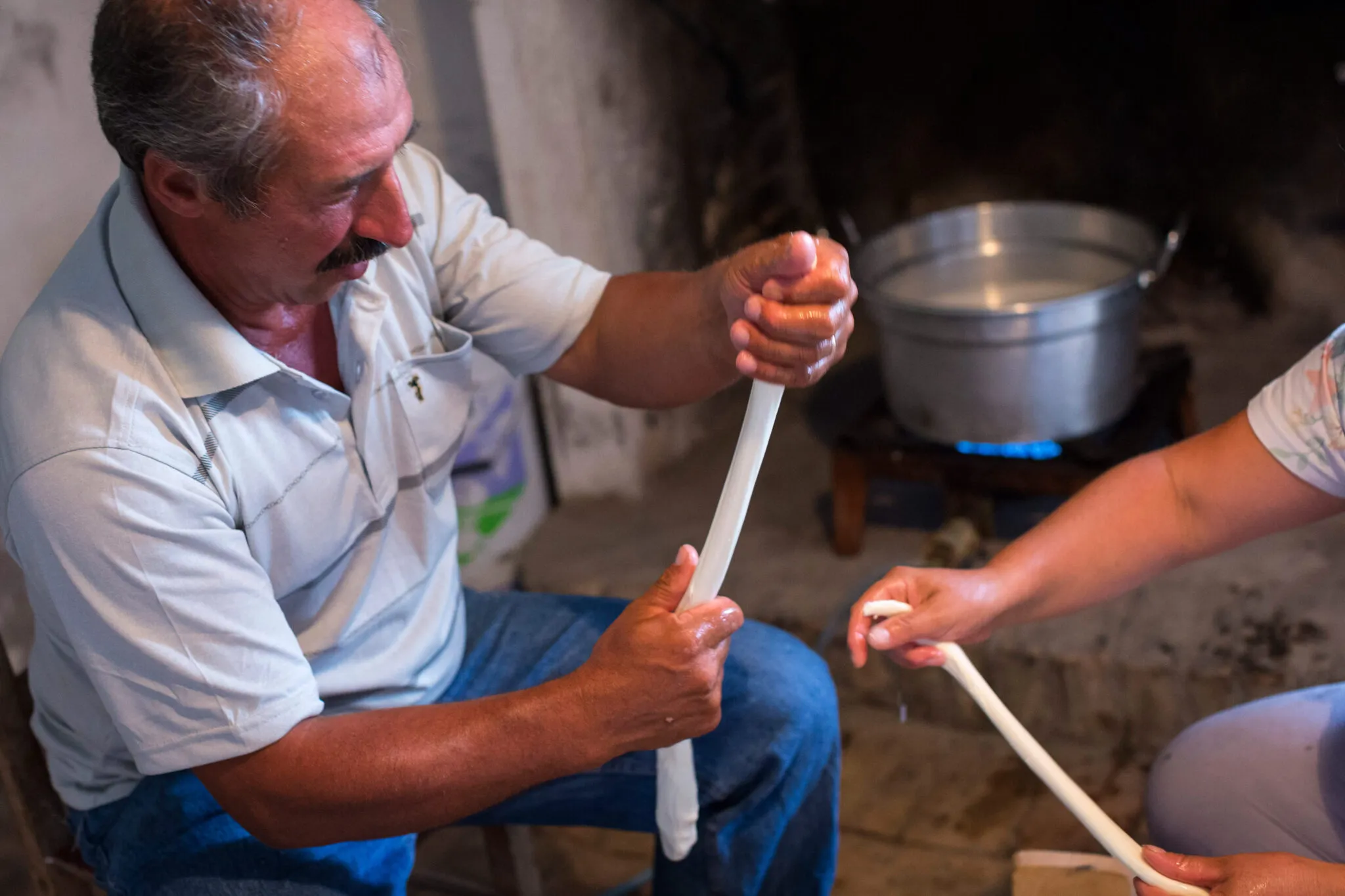 A man shows someone how to prepare fresh mozzarella