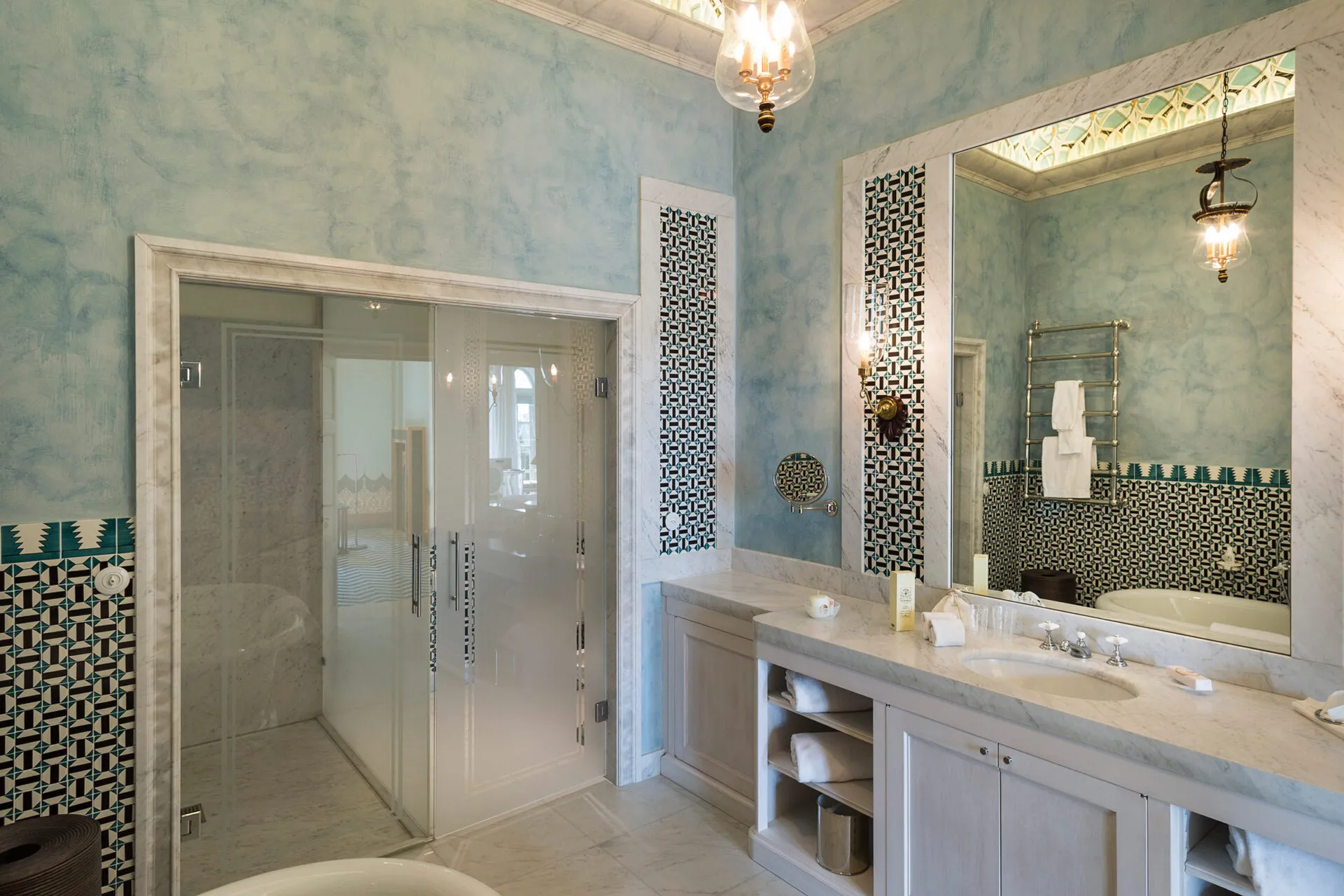 Bathroom with glass shower, marble vanity and geometric tile
