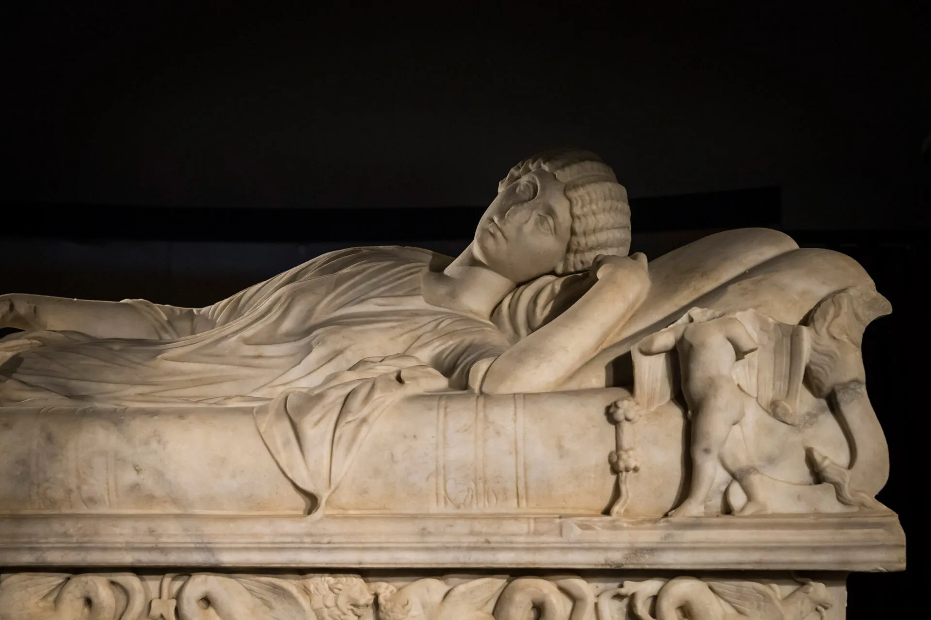Detail of a woman carved in stone on a sarcophagus