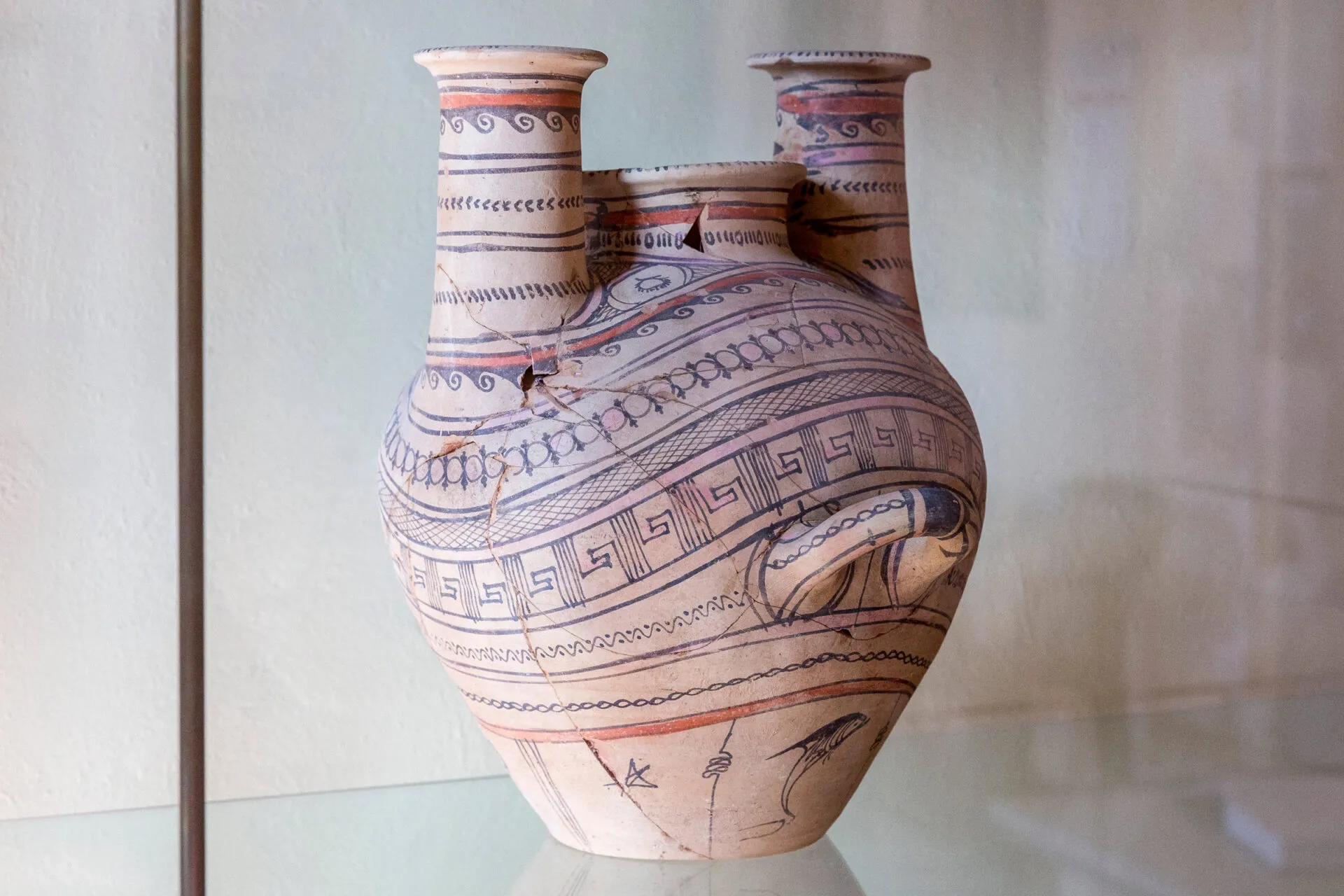 A clay pot with handle decorated with blue patterns