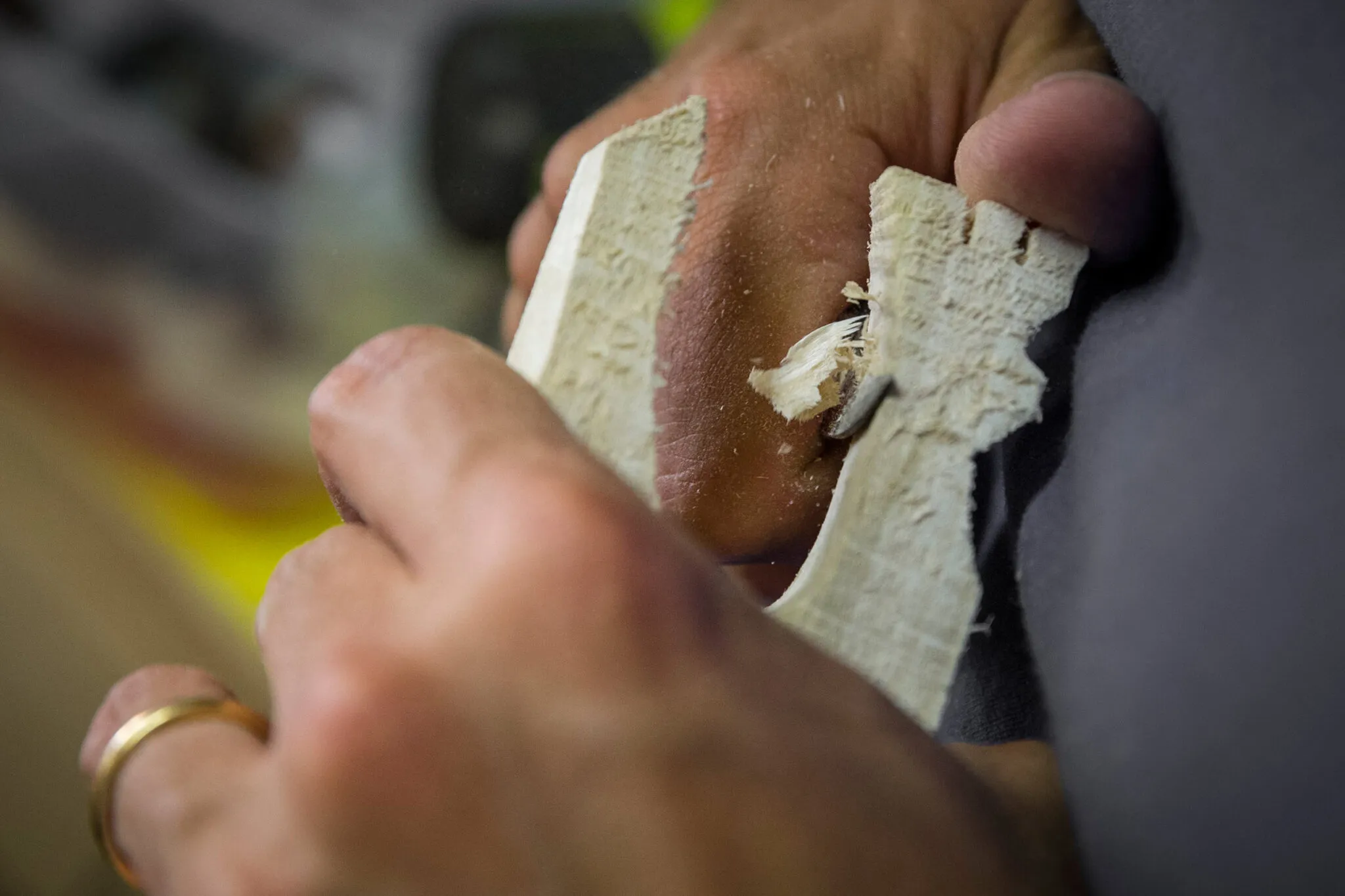 closeup of an artisan carving light wood